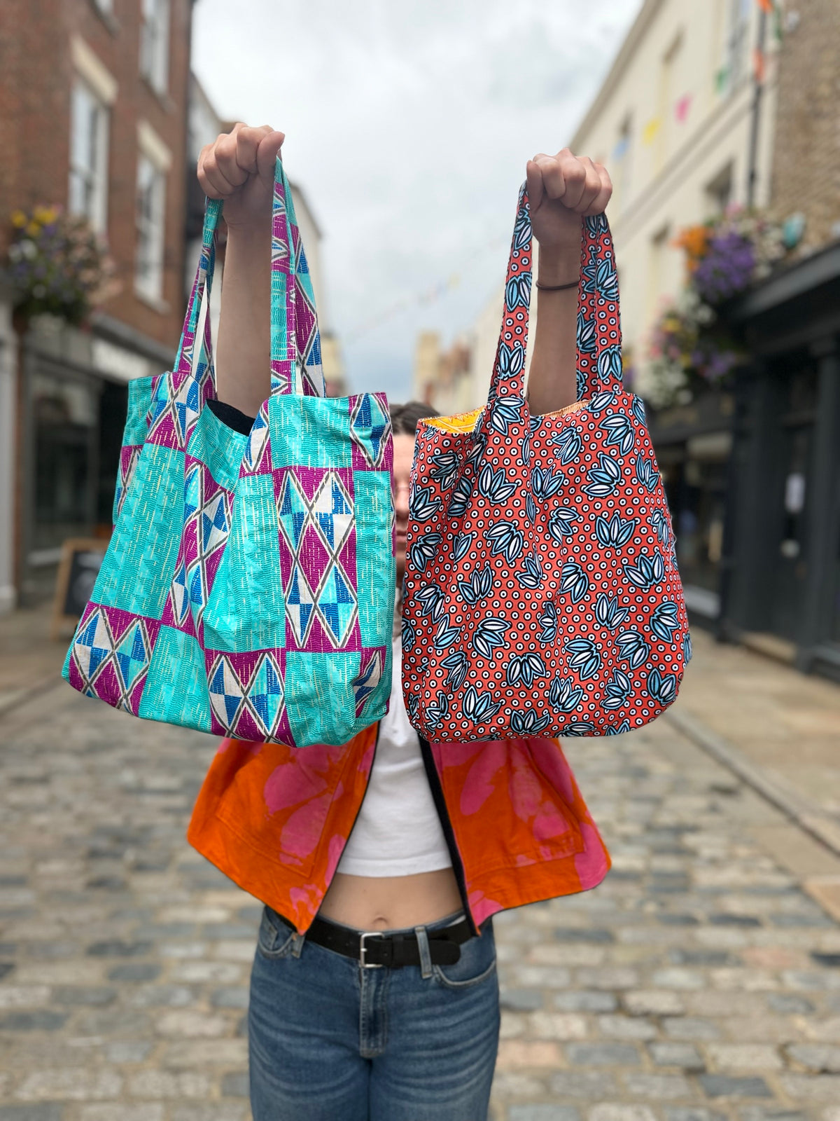 Handmade tote bags held up on Burgate, Canterbury